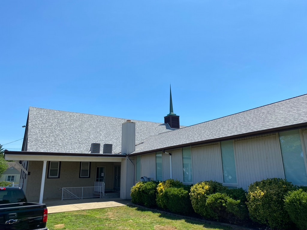 Wide view of church roof replacement in progress with Crossway sign visible